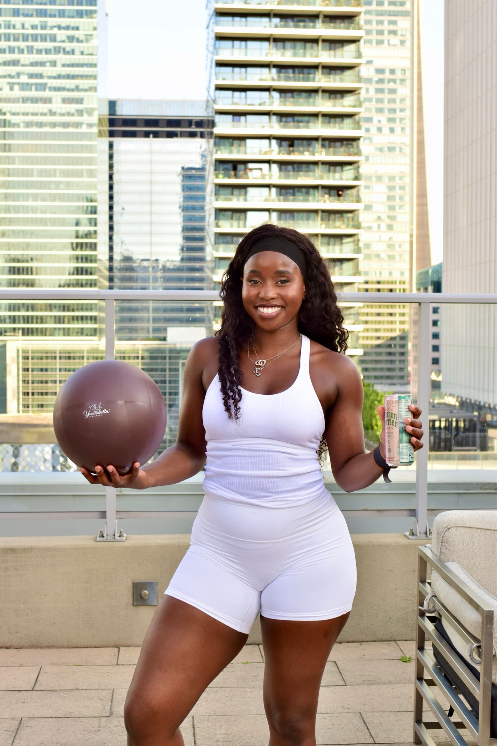 Yvette, ball in hand, the city behind her